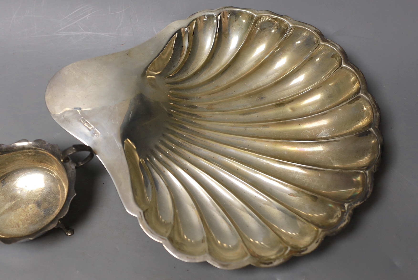 An Edwardian silver shell shaped dish, Atkin Brothers, Sheffield, 1904, 28.1cm and a silver sauceboat, 13.3oz.